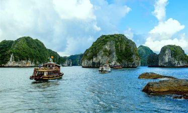 Vivid scene of boats sailing through stunning limestone karsts in Lan Ha Bay, perfect for kayaking a.