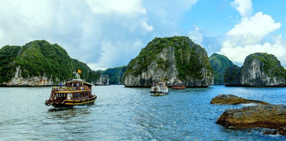 Vivid scene of boats sailing through stunning limestone karsts in Lan Ha Bay, perfect for kayaking a.
