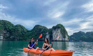 Kayaking in Halong Bay with stunning limestone karsts and tranquil waters, perfect for a peaceful es.