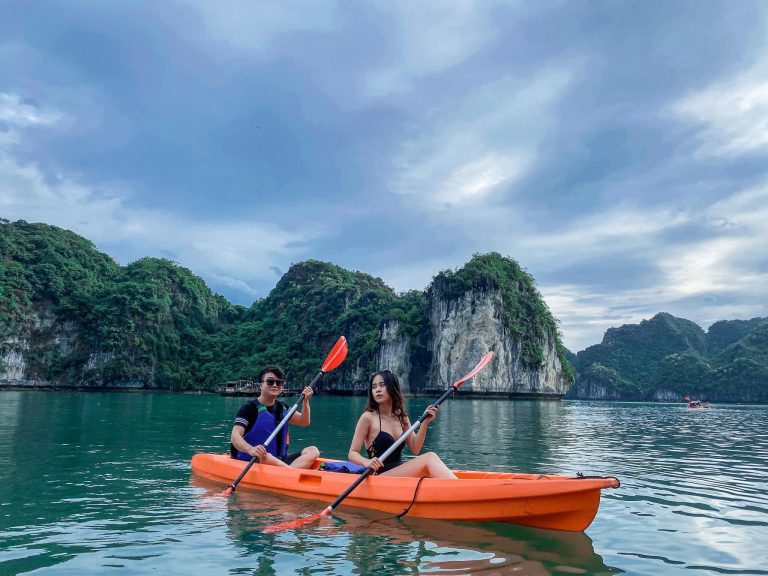 Kayaking in Halong Bay with stunning limestone karsts and tranquil waters, perfect for a peaceful es.