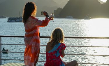 Stunning Halong Bay scenery with friends enjoying a relaxing cruise balcony experience. Perfect for.