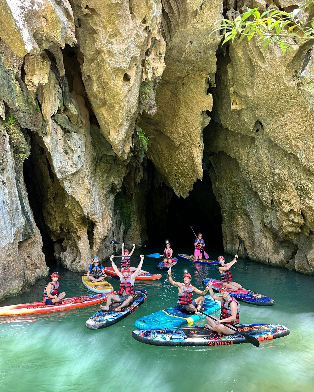 People kayaking in a scenic limestone cave at Halong Bay, Vietnam, enjoying a peaceful and exciting.