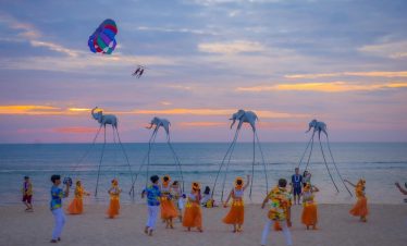 Phu Quoc Tours - Traditional dance and giant puppets on Halong Bay beach at sunset, vibrant cultural scene and lively.