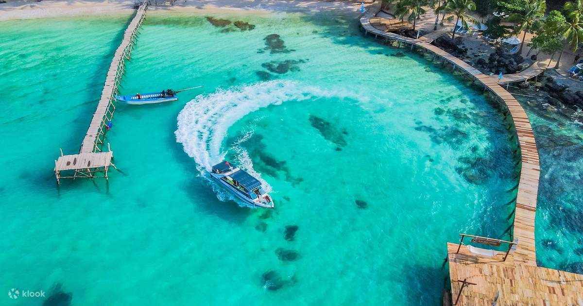 Aerial view of a luxury cruise boat sailing through clear turquoise waters in Halong Bay, showcasing.
