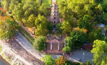 Aerial view of historic Hue temple surrounded by lush greenery and traditional architecture, perfect.