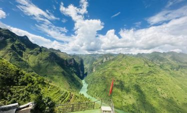 Stunning view of lush green Sapa mountains and river valley, perfect for trekking and nature explora.