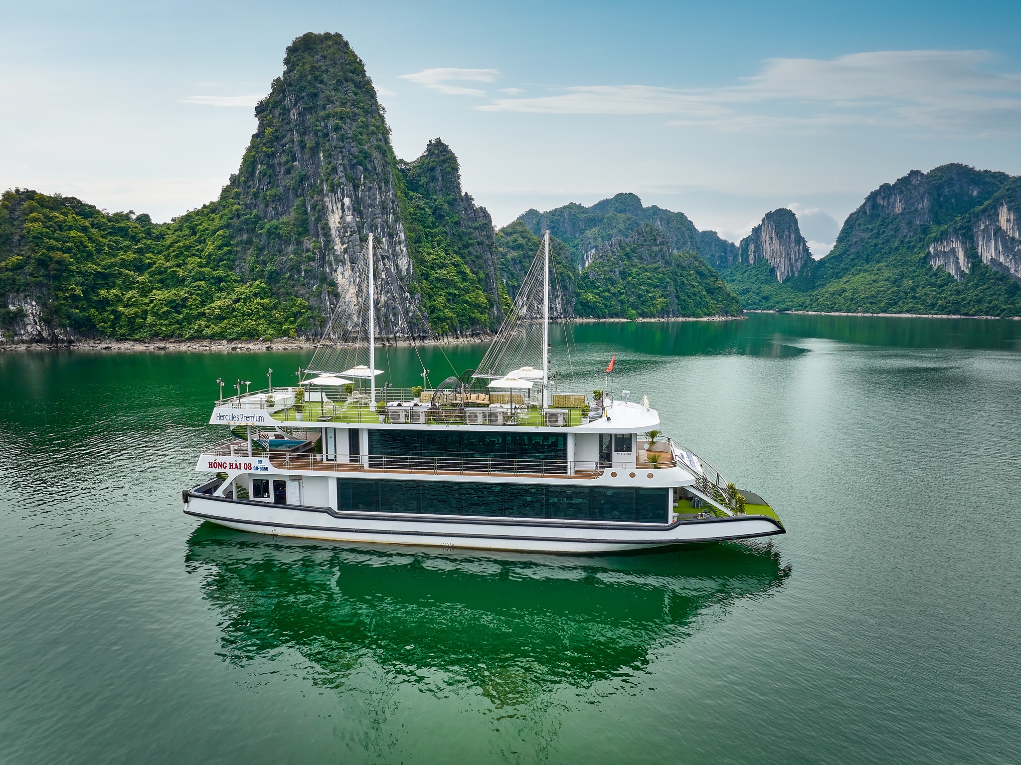 Luxurious boat sailing through stunning Halong Bay's iconic limestone formations, perfect for a memo.