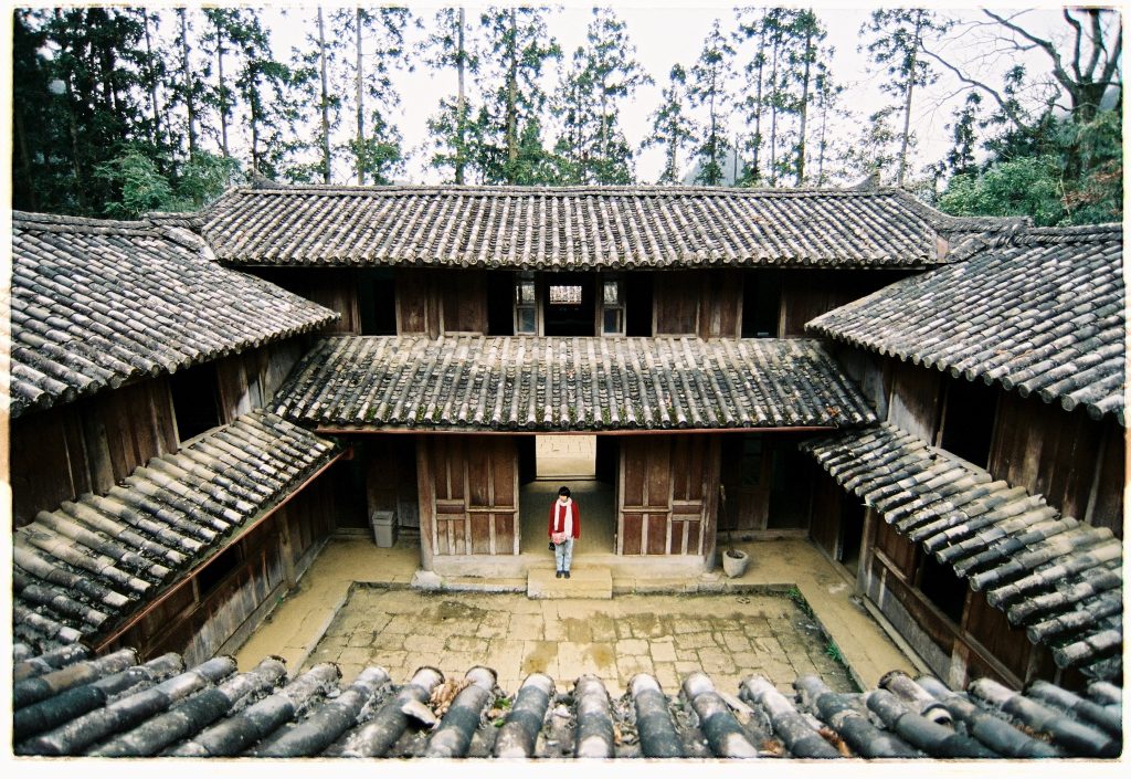 Ancient wooden house in Sapa surrounded by lush forest, showcasing authentic local architecture and.