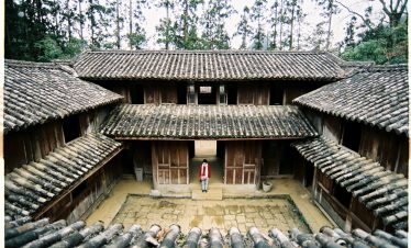 Ancient wooden house in Sapa surrounded by lush forest, showcasing authentic local architecture and.
