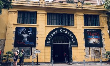 Vibrant scene outside Maison Centrale with travelers exploring historic architecture in Hanoi.