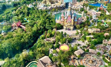 Aerial view of a vibrant amusement park with lush greenery and scenic landscapes in Vietnam.