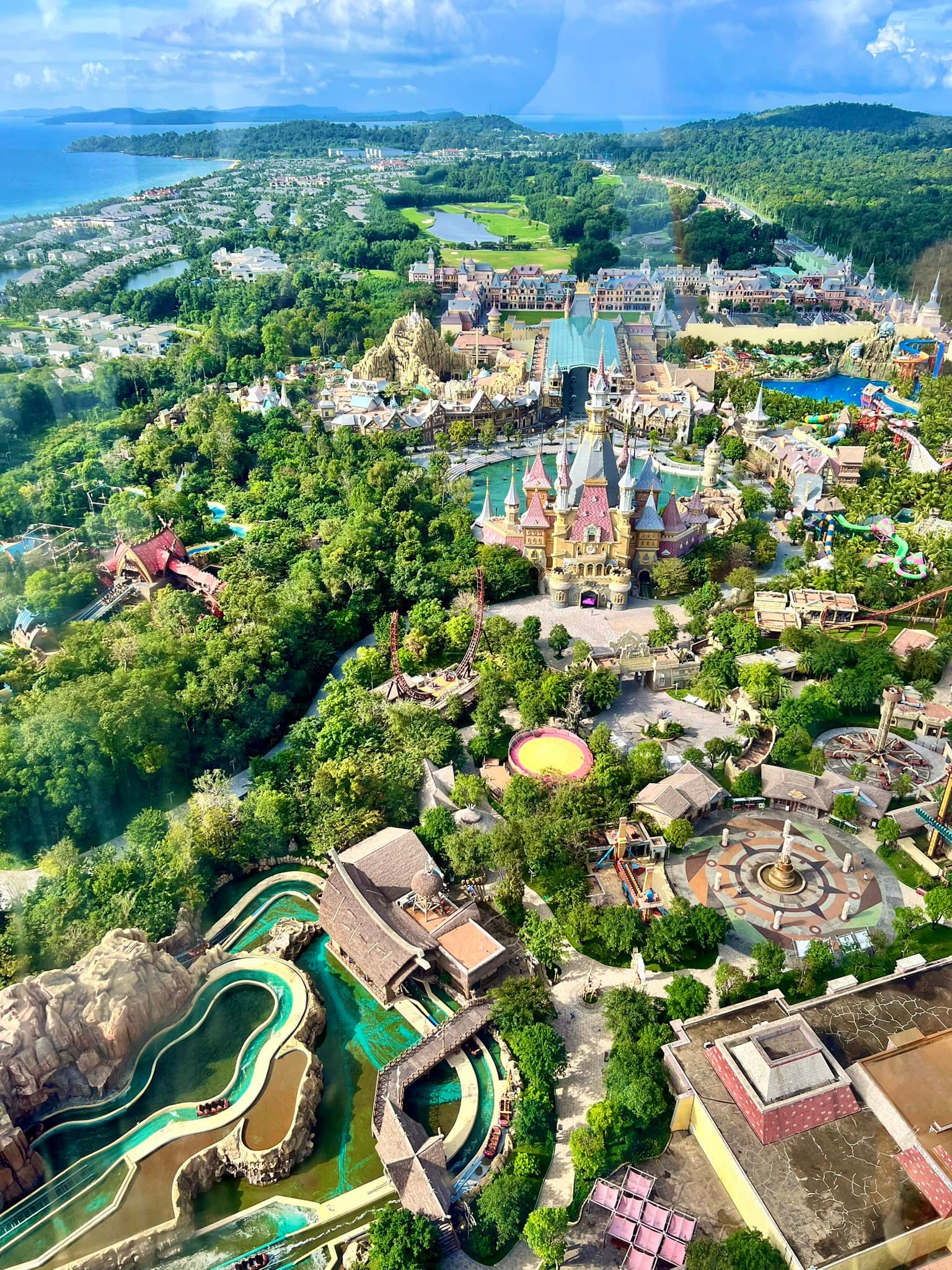 Aerial view of a vibrant amusement park with lush greenery and scenic landscapes in Vietnam.