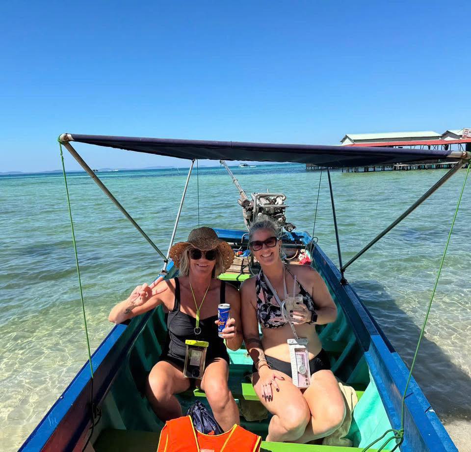Beautiful women enjoying Halong Bay cruise on a sunny day, relaxing on a traditional boat with clear.