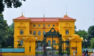 Majestic yellow Hanoi Palace with ornate gates, showcasing Vietnam's rich cultural heritage and rega.