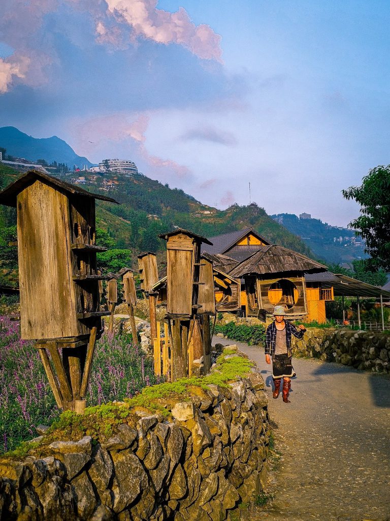 Scenic village scene in Vietnam with traditional houses and lush mountains in the background.