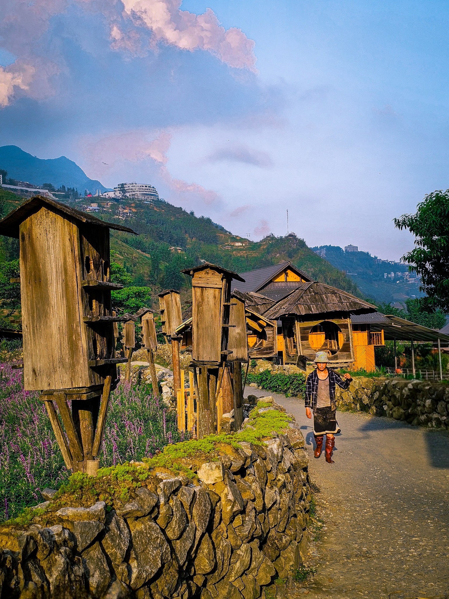 Scenic village scene in Vietnam with traditional houses and lush mountains in the background.