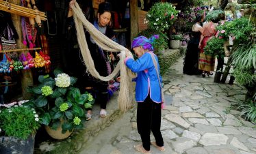 Vivid scene of local women shopping for handmade textiles at a vibrant Vietnamese market.