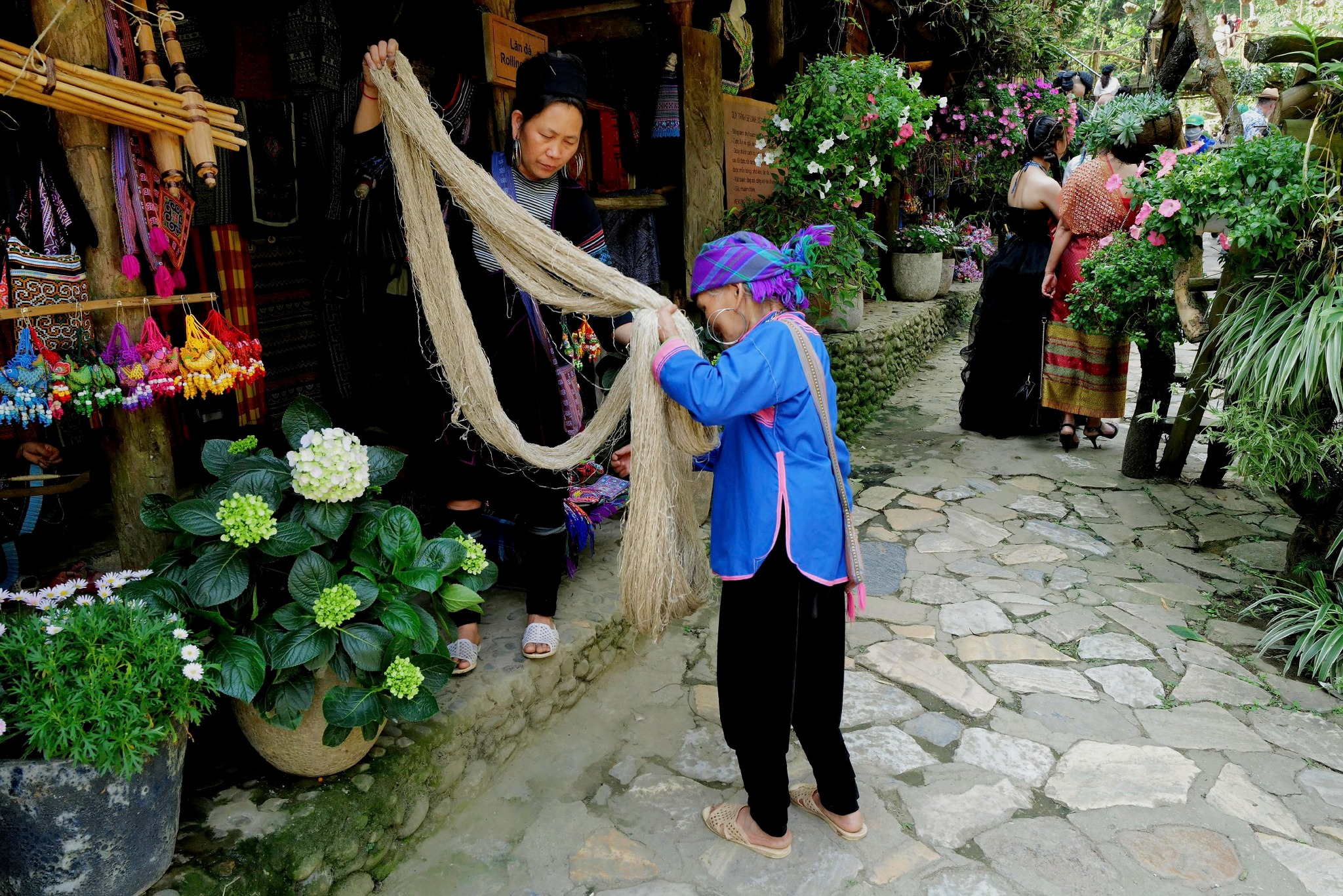 Vivid scene of local women shopping for handmade textiles at a vibrant Vietnamese market.
