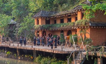 Vivid scene of tourists exploring Sapa's lush landscape and traditional houses during a guided trek.