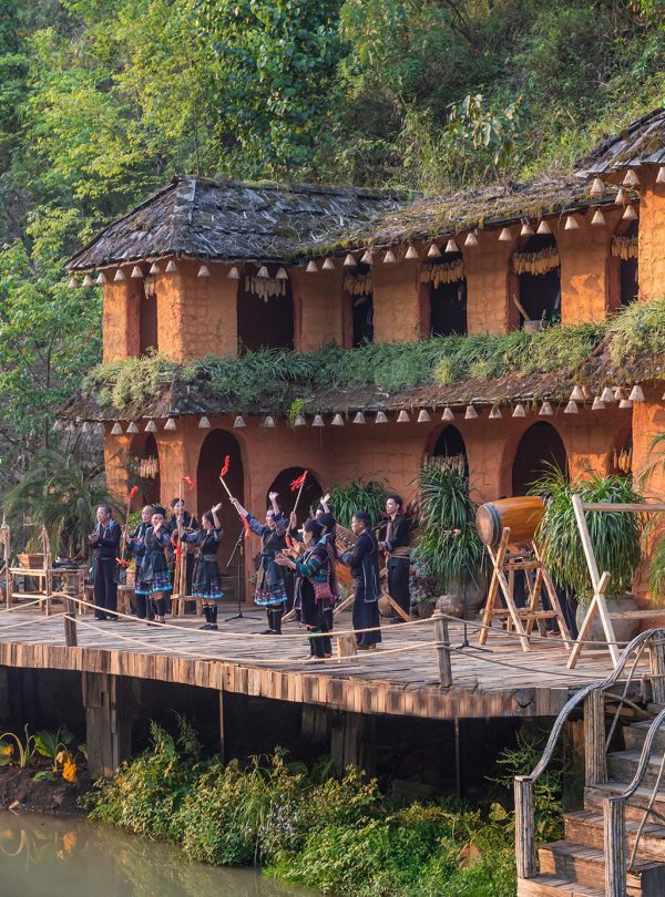 Vivid scene of tourists exploring Sapa's lush landscape and traditional houses during a guided trek.