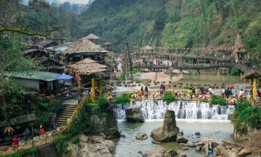 Vivid scene of river village with waterfalls, traditional houses, and visitors enjoying a peaceful,.