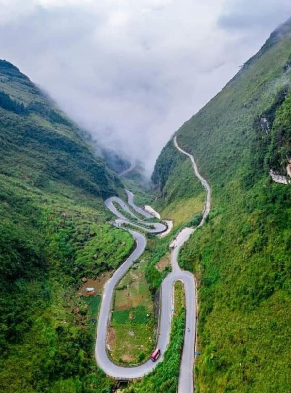 Stunning mountain pass in Sapa with winding roads and lush greenery, perfect for trekking and advent.
