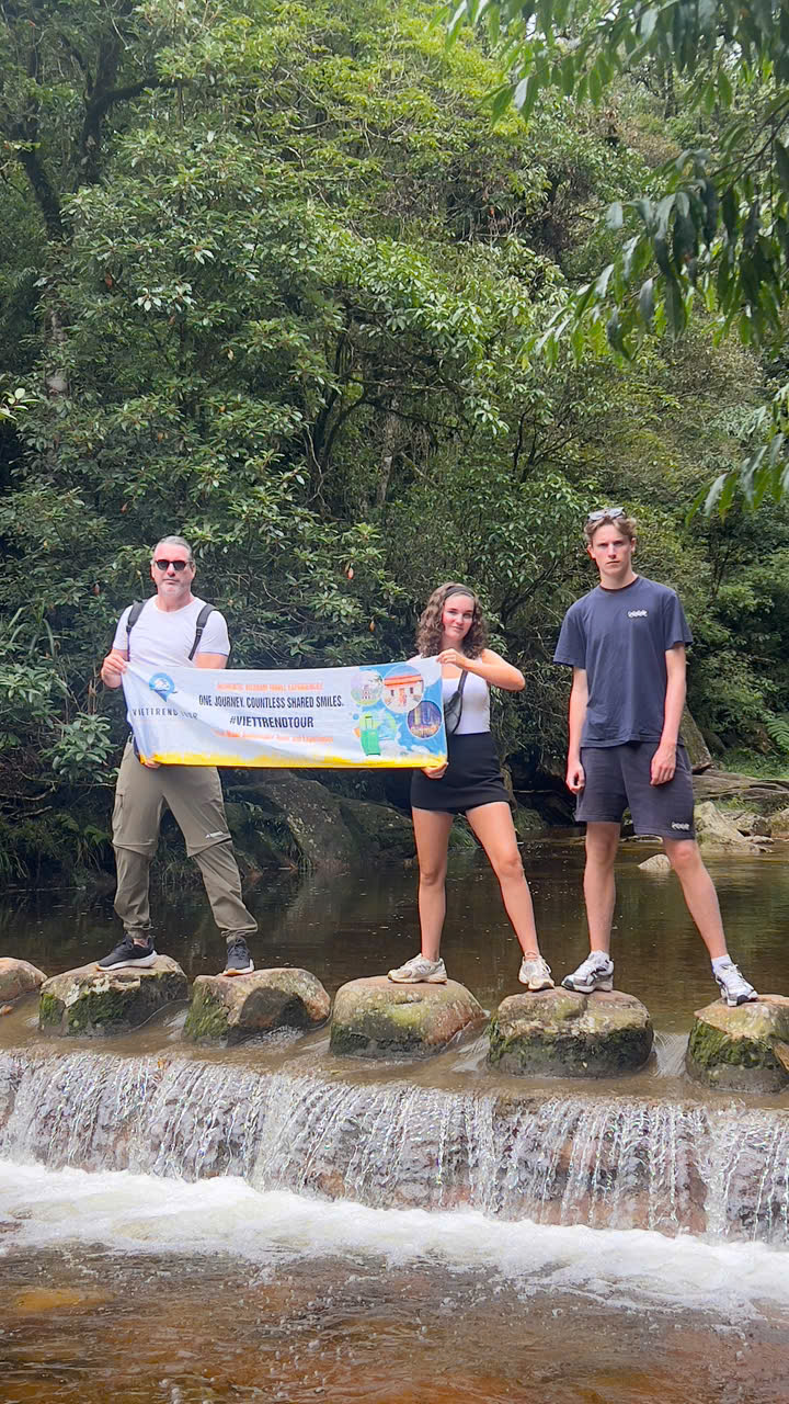 Hiking scene in Sapa's lush green landscape with travelers enjoying trekking adventure.