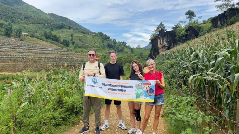 Group of travelers trekking through lush green Sapa mountains with scenic terraced fields and vibran.