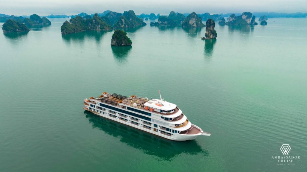 Halong Bay scenic view with cruise ship and limestone karsts, tranquil waters, and misty atmosphere.