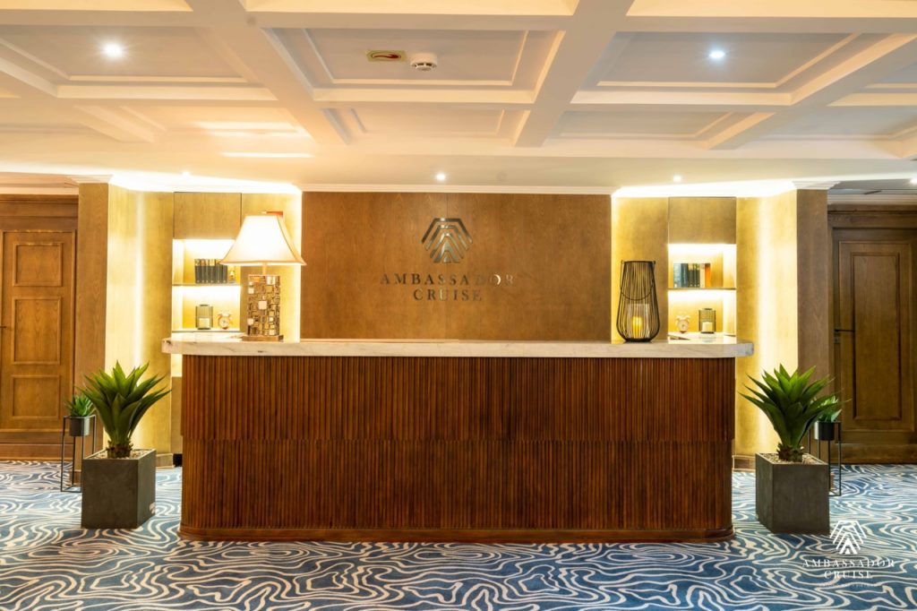 Elegant cruise reception with warm lighting and wooden accents in Halong Bay.