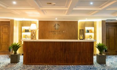 Elegant cruise reception with warm lighting and wooden accents in Halong Bay.