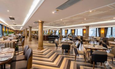 Luxurious cruise dining room with elegant decor and panoramic views of Halong Bay.