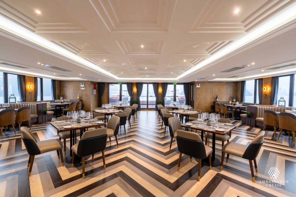 Luxurious cruise dining room with modern decor and panoramic bay views, perfect for a relaxing Halon.