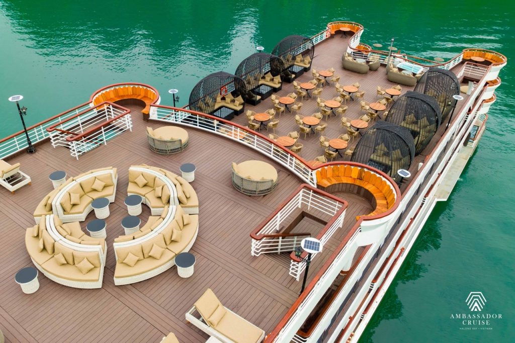Stunning view of Halong Bay from cruise balcony with relaxing seating area and turquoise waters.