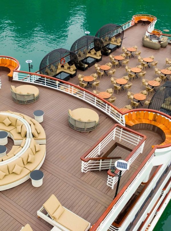 Stunning view of Halong Bay from cruise balcony with relaxing seating area and turquoise waters.