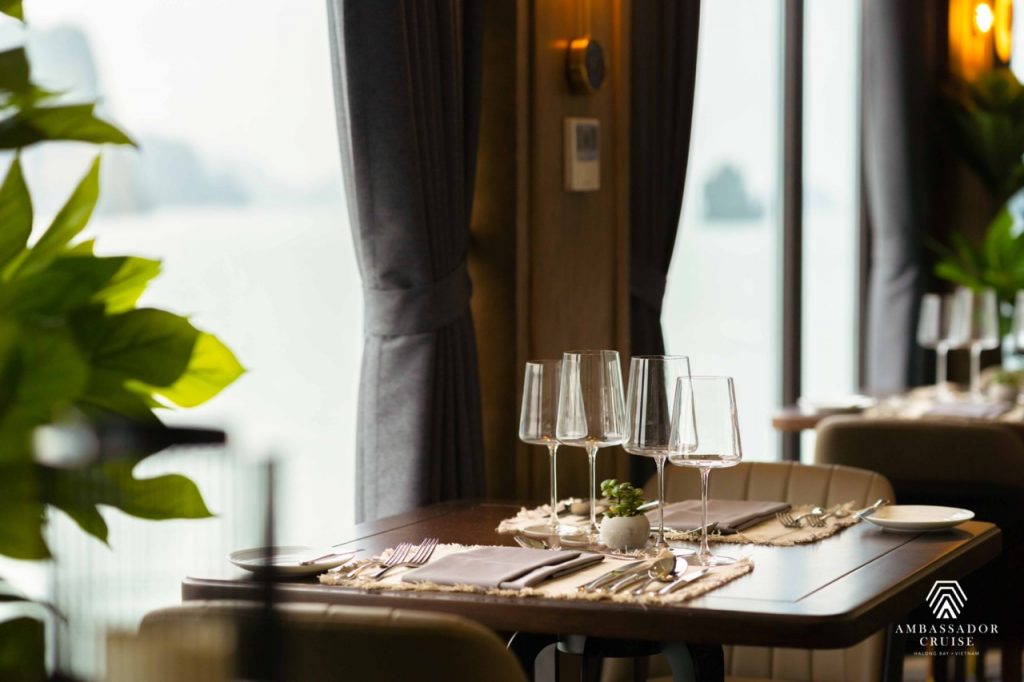 Stunning view from a cruise balcony in Halong Bay with elegant table setting and serene waters.