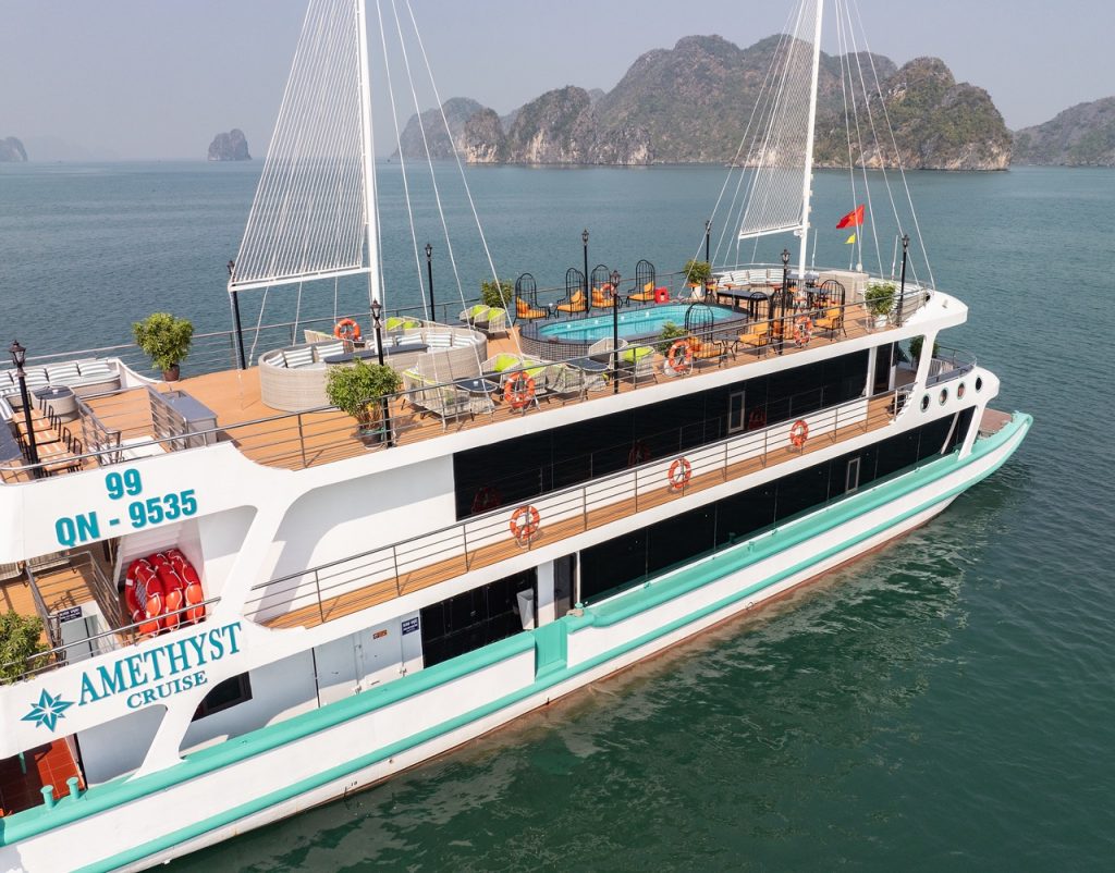 Stunning Halong Bay cruise ship with outdoor deck and swimming pool, scenic limestone islands, perfe.