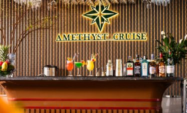 Elegant cruise bar with tropical cocktails and vibrant decor in Halong Bay.