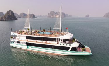 Aerial view of the Amethyst cruise sailing through Halong Bay's emerald waters with limestone karsts.