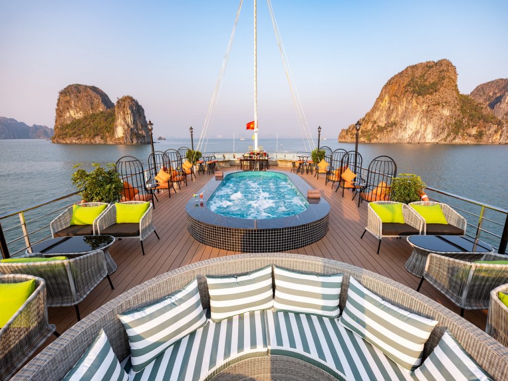 Luxurious cruise balcony overlooking Halong Bay with scenic limestone islands and calm waters.