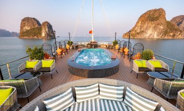 Luxurious cruise balcony overlooking Halong Bay with scenic limestone islands and calm waters.