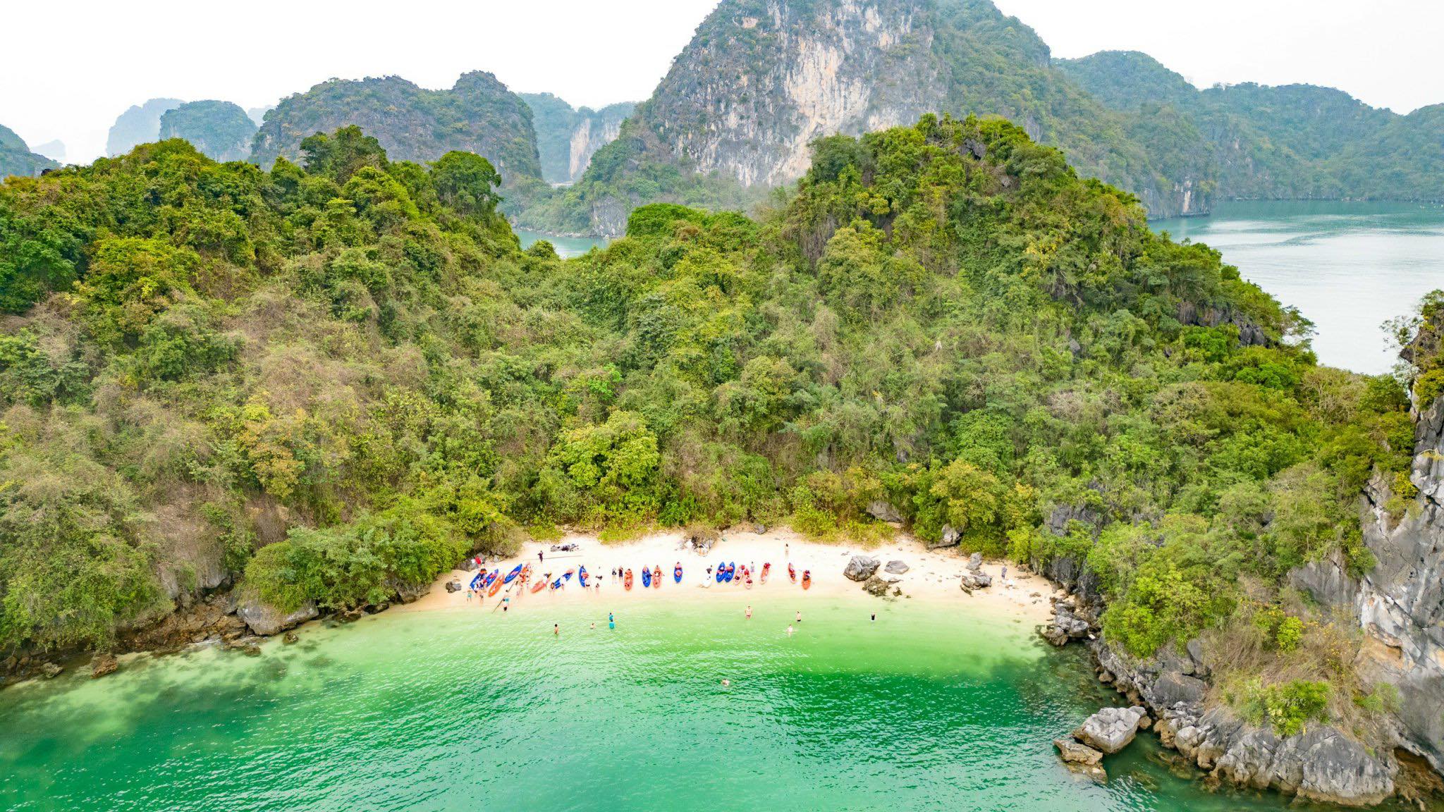 Scenic view of Halong Bay's emerald waters and lush islands from a luxury cruise balcony.