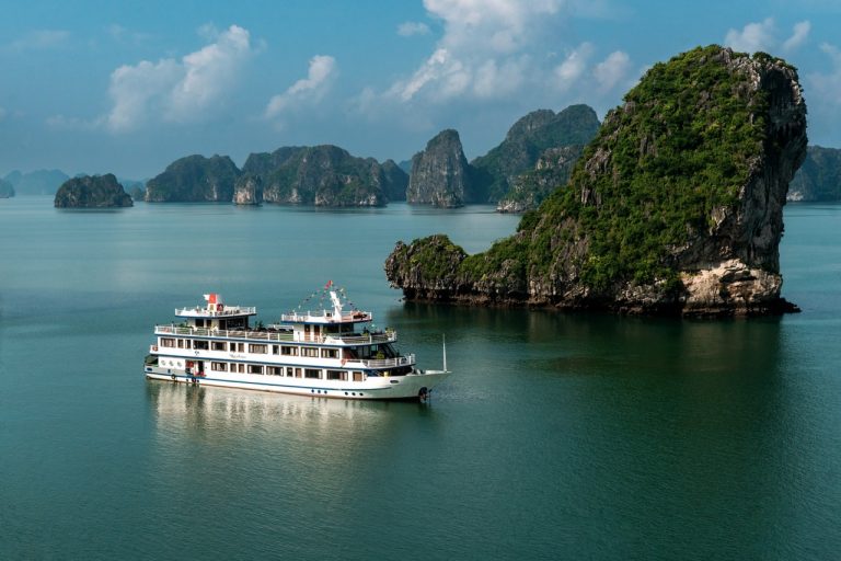 Stunning Bai Tu Long Bay Cruise 1 Night landscape with cruise ship and towering limestone islands.
