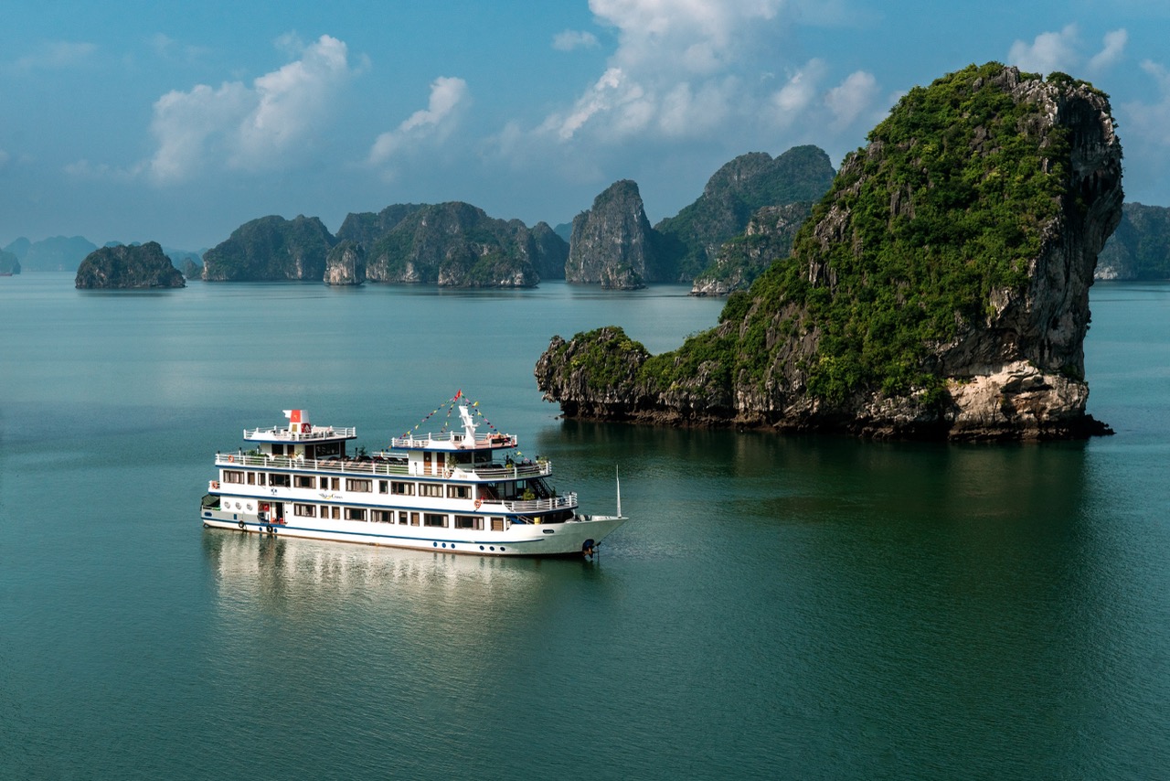 Stunning Bai Tu Long Bay Cruise 1 Night landscape with cruise ship and towering limestone islands.
