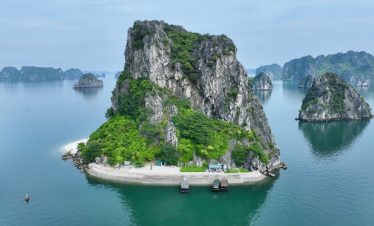 Scenic view of Bai Tu Long Bay with towering limestone islands and emerald waters, perfect for luxur.