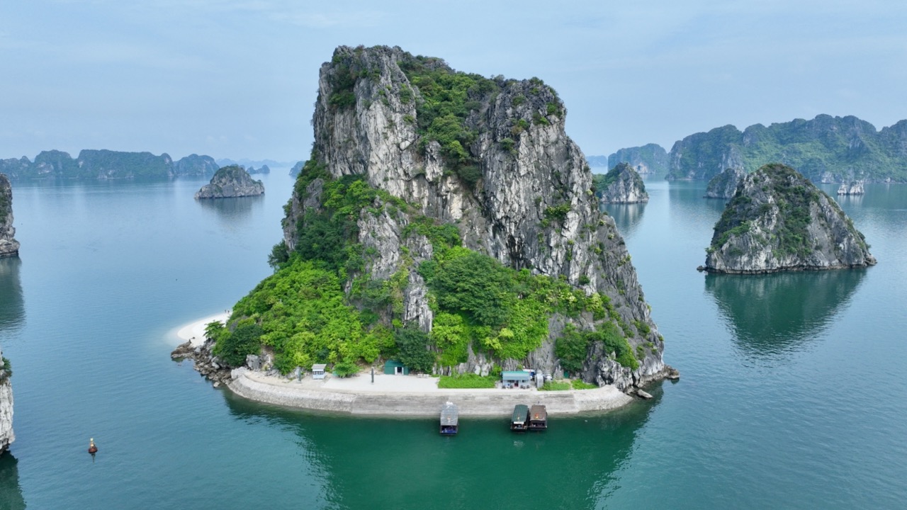 Scenic view of Bai Tu Long Bay with towering limestone islands and emerald waters, perfect for luxur.