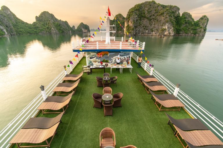 Scenic Bai Tu Long Bay cruise deck with lounge chairs and panoramic views, perfect for relaxing and.