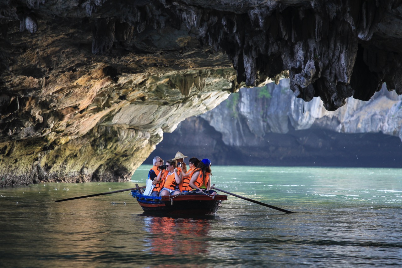 Kayakers exploring Halong Bay's stunning limestone karsts and emerald waters on a peaceful cruise.
