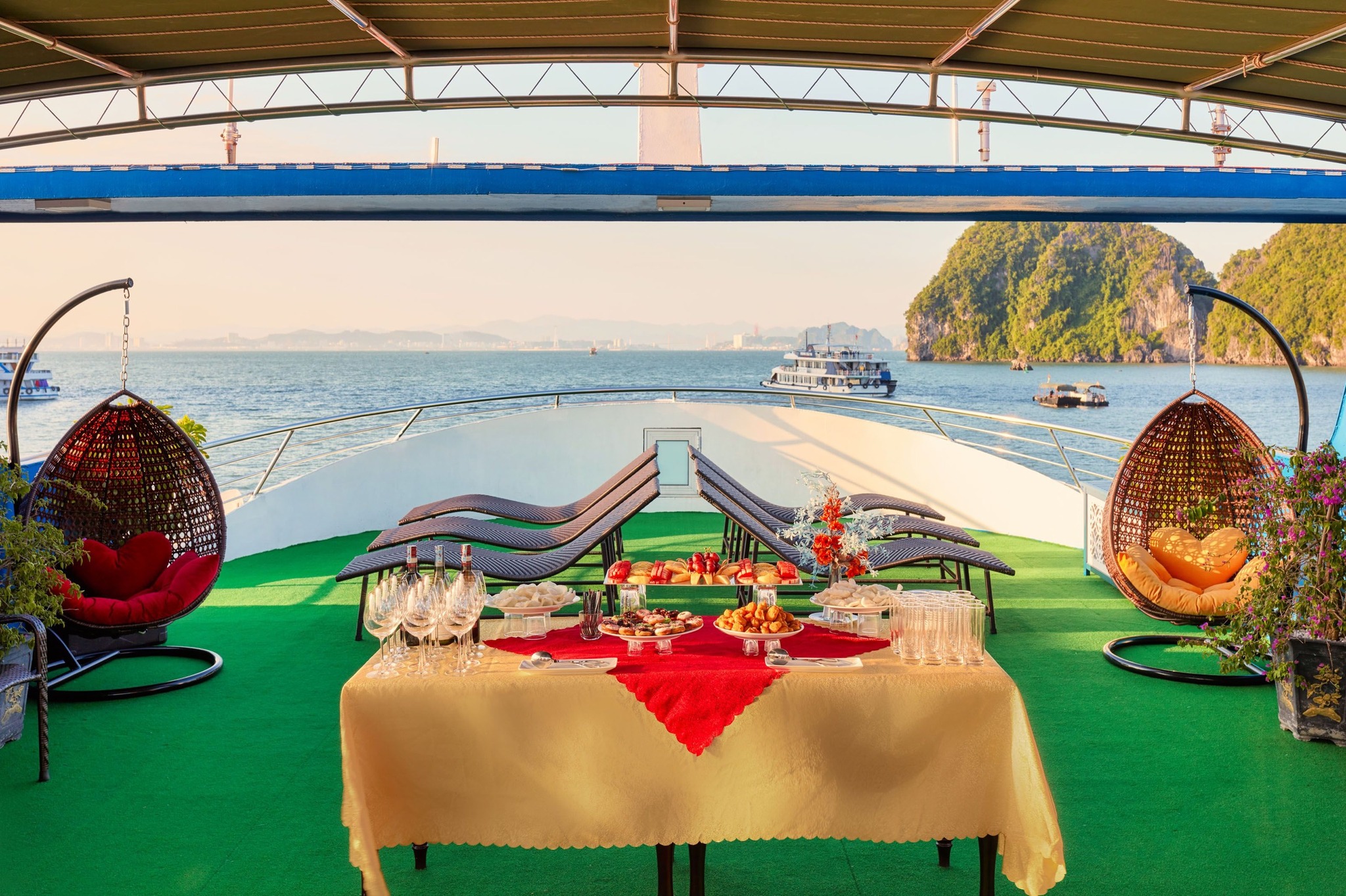 Stunning view of Ha Long Bay with luxurious cruise balcony and scenic limestone karsts.