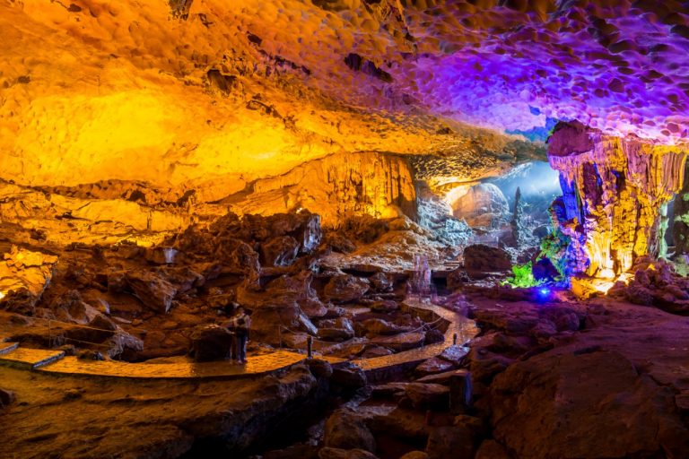 Halong Bay cruise balcony with colorful cave lighting, scenic views, and tranquil atmosphere.